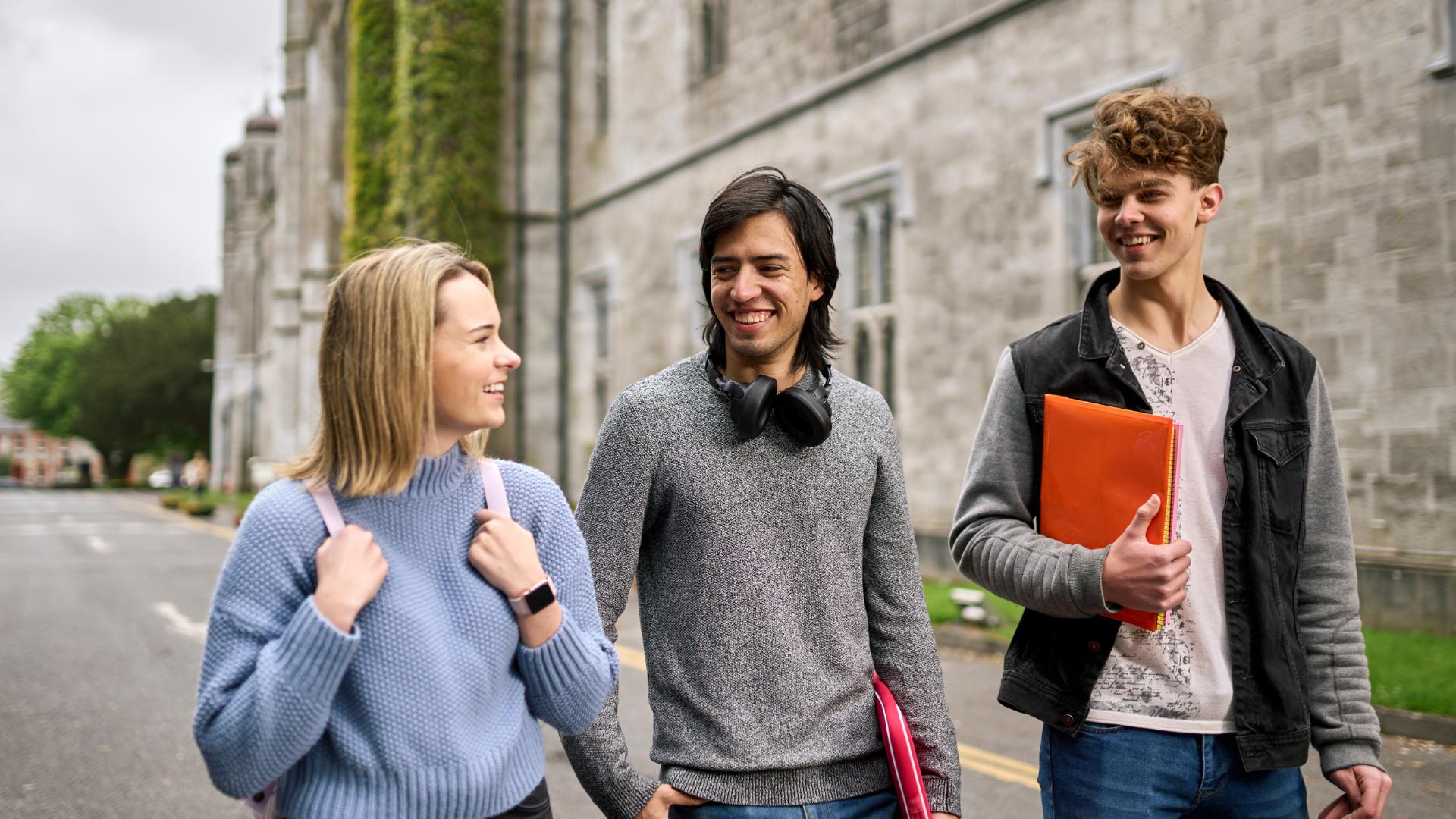 Three students walking outside the Quadrangle